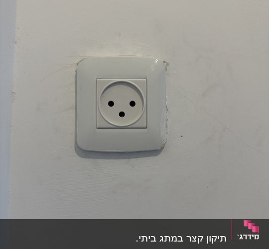 שקע חשמל בקיר לבן